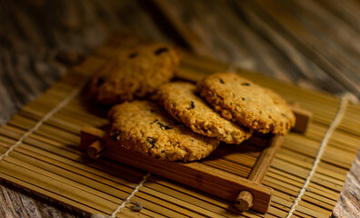 Close-up pile of delicious homemade chocolate chip cookies on black stone floor. Presented with copy space, top view.