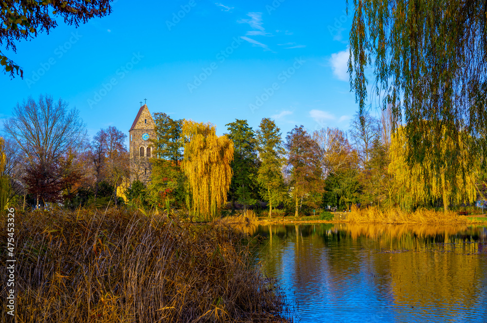 Sticker village pond with reflections of colorful trees in the water.