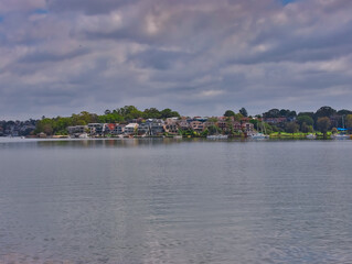 Fototapeta na wymiar Panorama view of Concord Bay on Sydney Harbour NSW Australia, wealthy houses on the forshore nestled between lush green trees