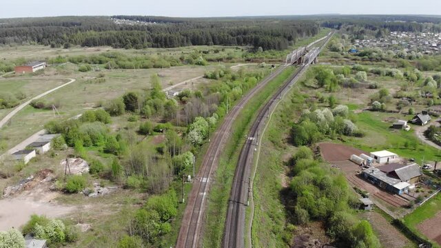 Aerial view of a passenger train that passes over a small bridge (Strizhi, Kirov region, Russia)