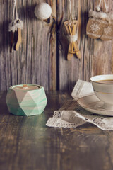 Handmade soy wax candle in a clay candlestick .