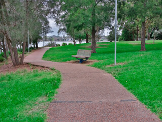 lonely park bench in a park Concord Bay with a winding footpath Sydney NSW Australia 
