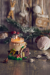 Fototapeta na wymiar A burning handmade candle on the background of Christmas decor .