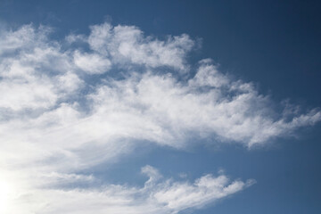 Background Texture of a clear blue sky, with an interesting white cloud pattern.