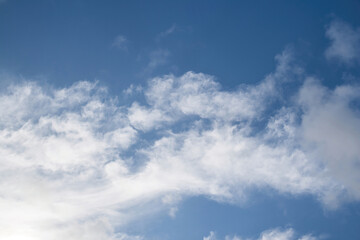 Background Texture of a clear blue sky, with an interesting white cloud pattern.