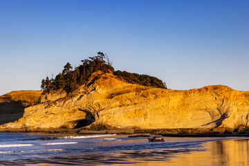 Fishing Dory Boat heads out at sunrise at Cape Kiwanda in Pacific City, Oregon, USA