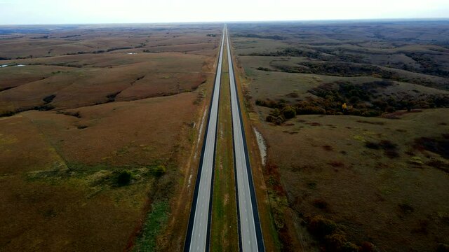 Long highway road that seems to go on forever alongside beauteous Midwestern fall foliage