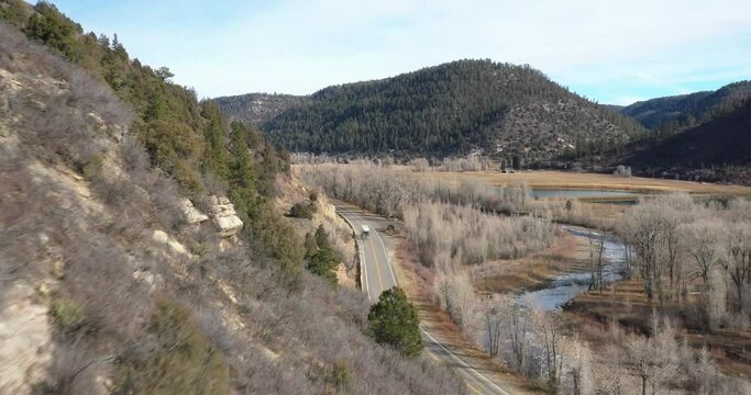 Mountain View in Colorado with semi-truck driving down road. Drone shot moving forward.