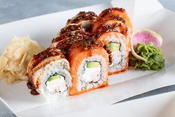 Sushi roll (Philadelphia) with salmon, smoked eel, cream cheese on light table. Sushi menu. Japanese food.