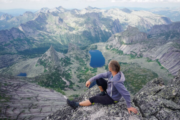 Naklejka premium Hiker on top of a rock with a beautiful view of Ergaki natural practice