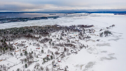 Fototapeta na wymiar Winter landscape - village, ice, lake, forest, snow. Old north houses.