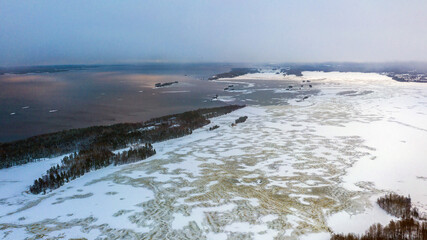 Winter landscape. Lake and ice. Island and forest. Snow and water.