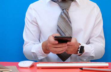 Man uses a smartphone. In the office, a businessman is working. Freelancing, student life, e-learning, studying, web site, technology.