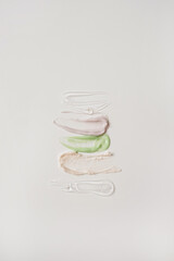 Close up of make up cosmetic products: neutral green, pink and transparent beauty, skincare cream isolated on white background. Minimalist beauty branding, merchandise concept