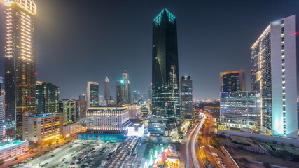 Naklejka na ściany i meble Dubai International Financial district aerial all night timelapse. Panoramic view of business and financial office towers.