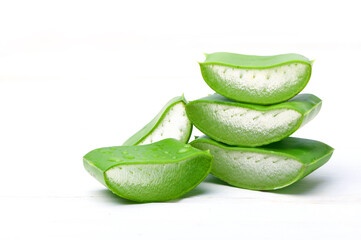 Close-up Aloe vera slices with water droplets on white background.