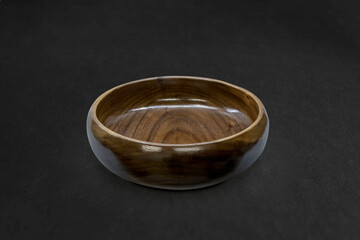 Empty wooden bowl with black background