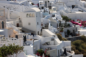 Whitewashed houses with terraces and pools and a beautiful view in Oia on Santorini island, Greece