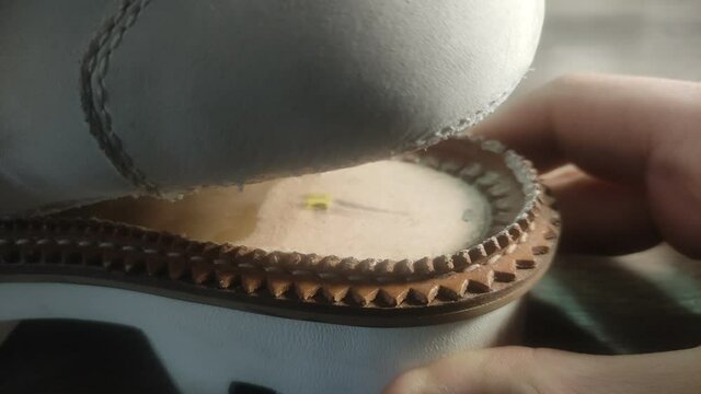 On white shoes, the sole has come off due to old glue, shoe repair is done by a shoemaker	
