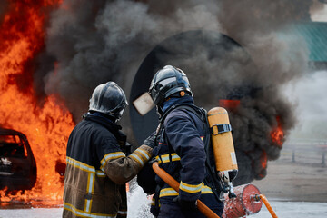 Tres bomberos frente a un incendio con fuego - obrazy, fototapety, plakaty