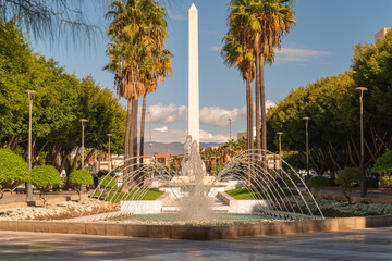 Plaza con fuente de agua y monumento en la ciudad.