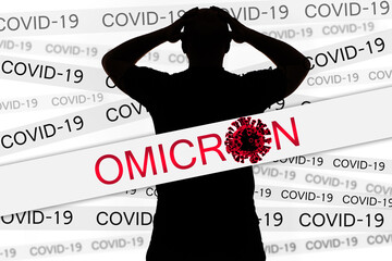 Omicron and Covid-19 titles on paper strips. Omicron variant of COVID-19. Man clutched his head...