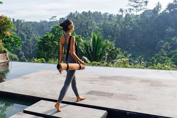 Foto op Aluminium Girl with yoga mat with tropical look. © Sergei