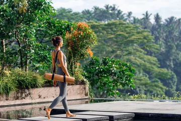 Foto op Plexiglas Girl with yoga mat with tropical look. © Sergei