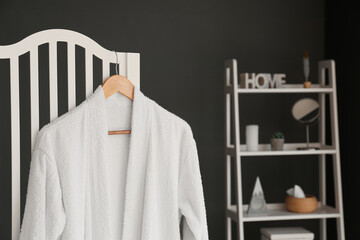 White bathrobe hanging on folding screen in room