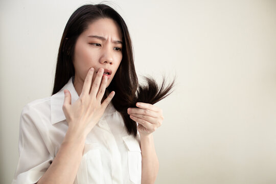 Asian Beautiful Woman Using Hand Touch On Lip And Hold Her Hair With Worried Face And Shocked About Hair Split And Dry Problem