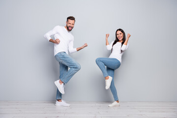 Full body photo of cool millennial couple yell wear shirt jeans footwear isolated concrete grey color wall background