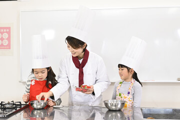 社会見学の体験教室で、お菓子の作り方を学ぶ小学生の女の子