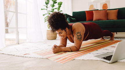 Healthy woman holding plank position at home