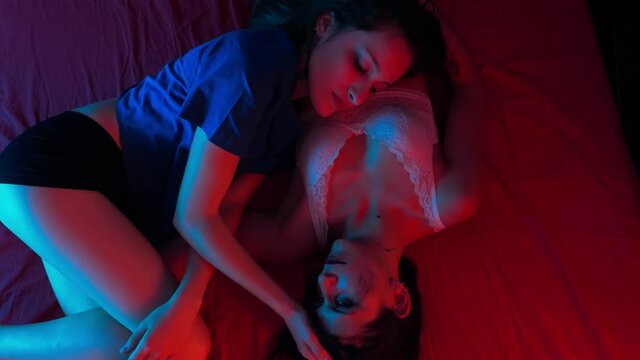 young lesbians lying on the bed fondle each other tenderly