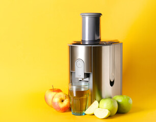 Modern juicer with fresh fruits on color background