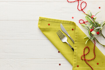 Beautiful cutlery with Christmas decor on light wooden background