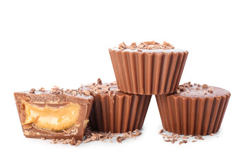 Tasty peanut butter cups on white background