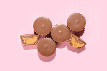 Tasty peanut butter cups on color background