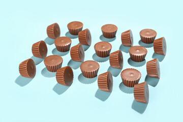 Tasty peanut butter cups on color background
