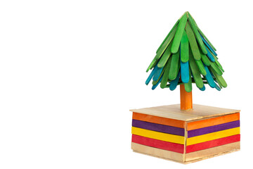 Christmas tree on a gift box made from colorful popsicle sticks isolated on a white background included clipping path. It's creativity and imagination.