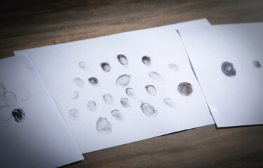 Black prints of fingers on paper.