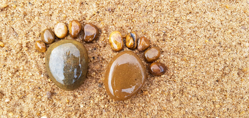 feet made of stones in the sand