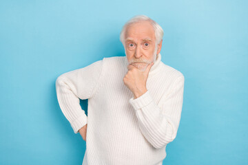 Portrait of attractive funny bewildered suspicious grey-haired man making decision isolated over vivid blue color background