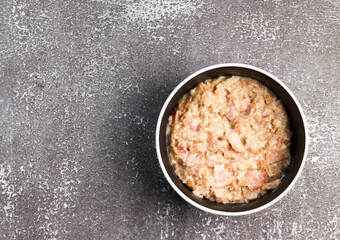 Cheesy bacon savory oatmeal in a bowl on a dark background. Top view, flat lay