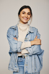 Stylish young woman smiling at the camera in a studio - obrazy, fototapety, plakaty