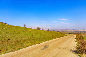 Fototapeta na wymiar Dirt road, landscape, and Mount Hermon. The Golan Heights