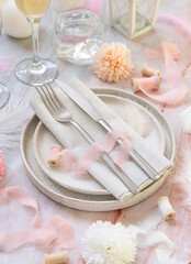Wedding Table place near flowers, silk ribbons and feathers on a marble table