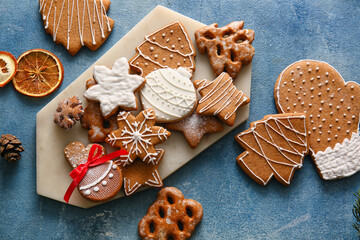Board with delicious Christmas cookies on color background