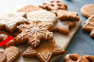 Board with tasty Christmas cookies on color background, closeup