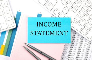 INCOME STATEMENT text on blue sticker on chart with calculator and keyboard,Business concept